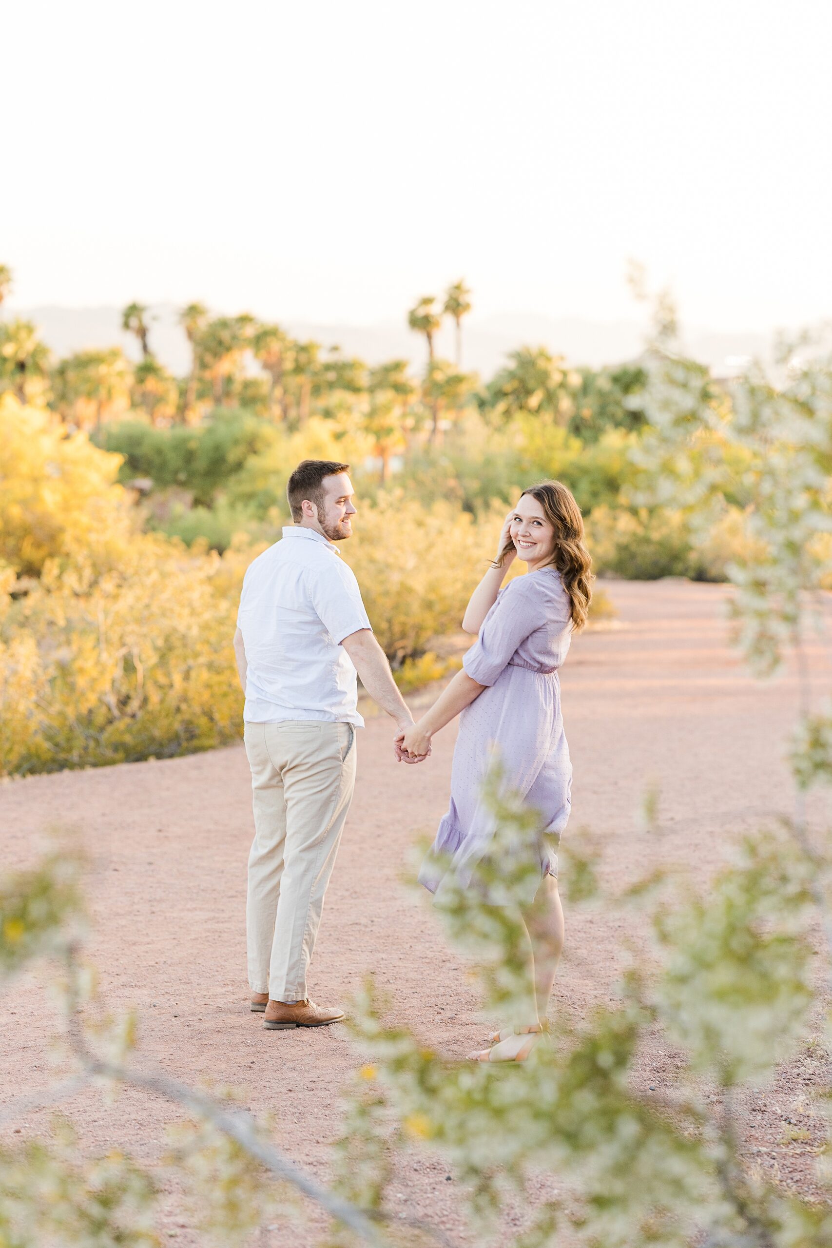A lovely moment of the couple walking hand in hand during their engagement session at Papago Park
