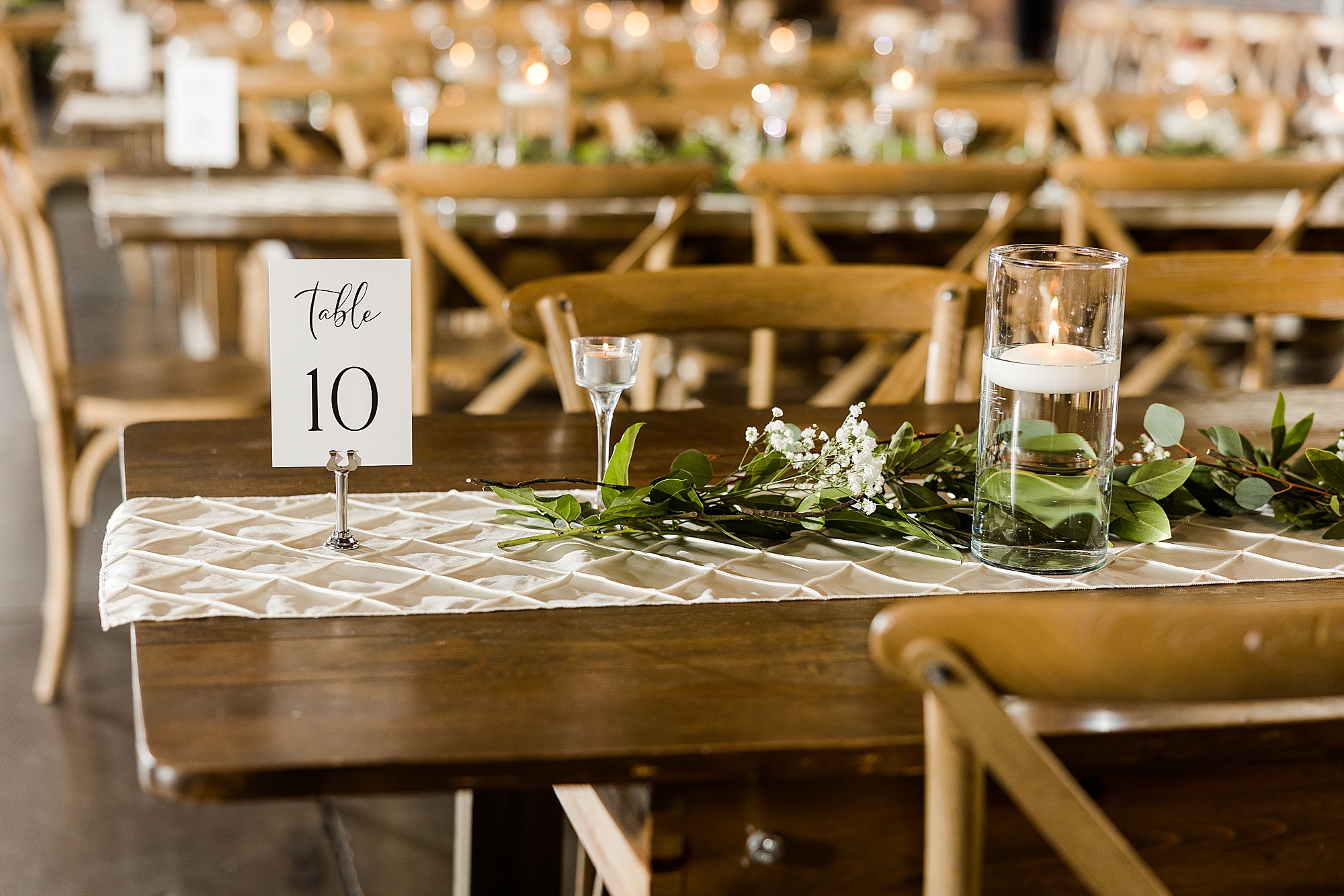 Wedding reception table with white linens and gold accents

