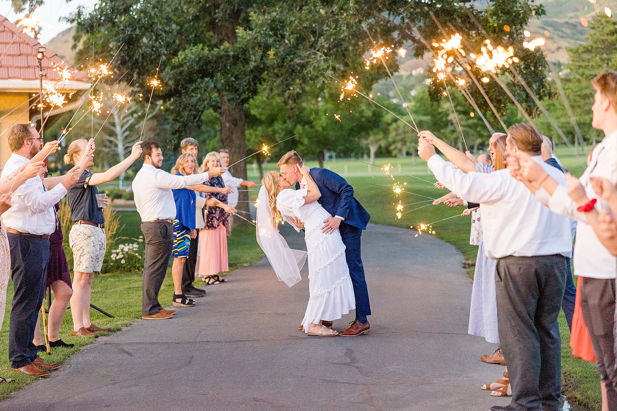 The couple kiss while sparklers illuminate their grand exit