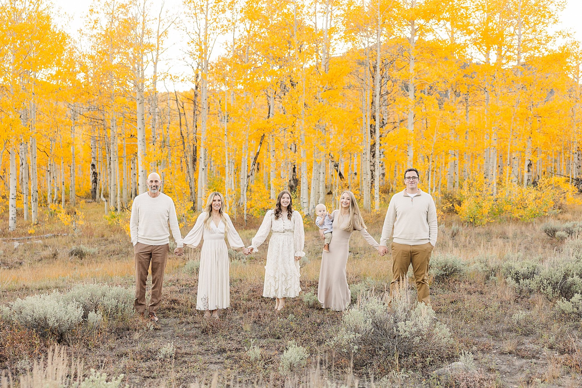 Family of three playing in a meadow during a Utah photo shoot.
